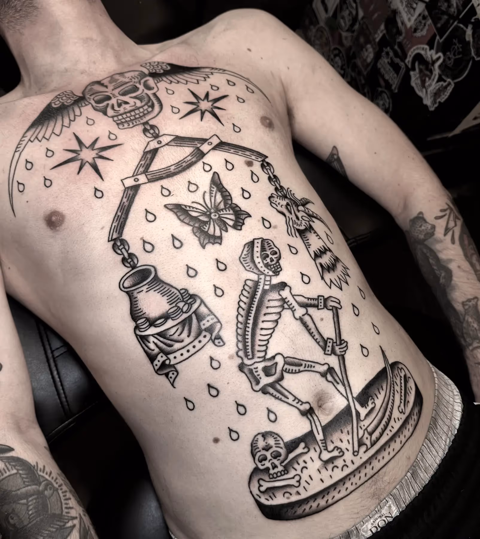 Blackwork borststuk tattoo met skelet, weegschaal en vlinder, gezet door Nik Mart bij True Spirit Tattoo Barendrecht