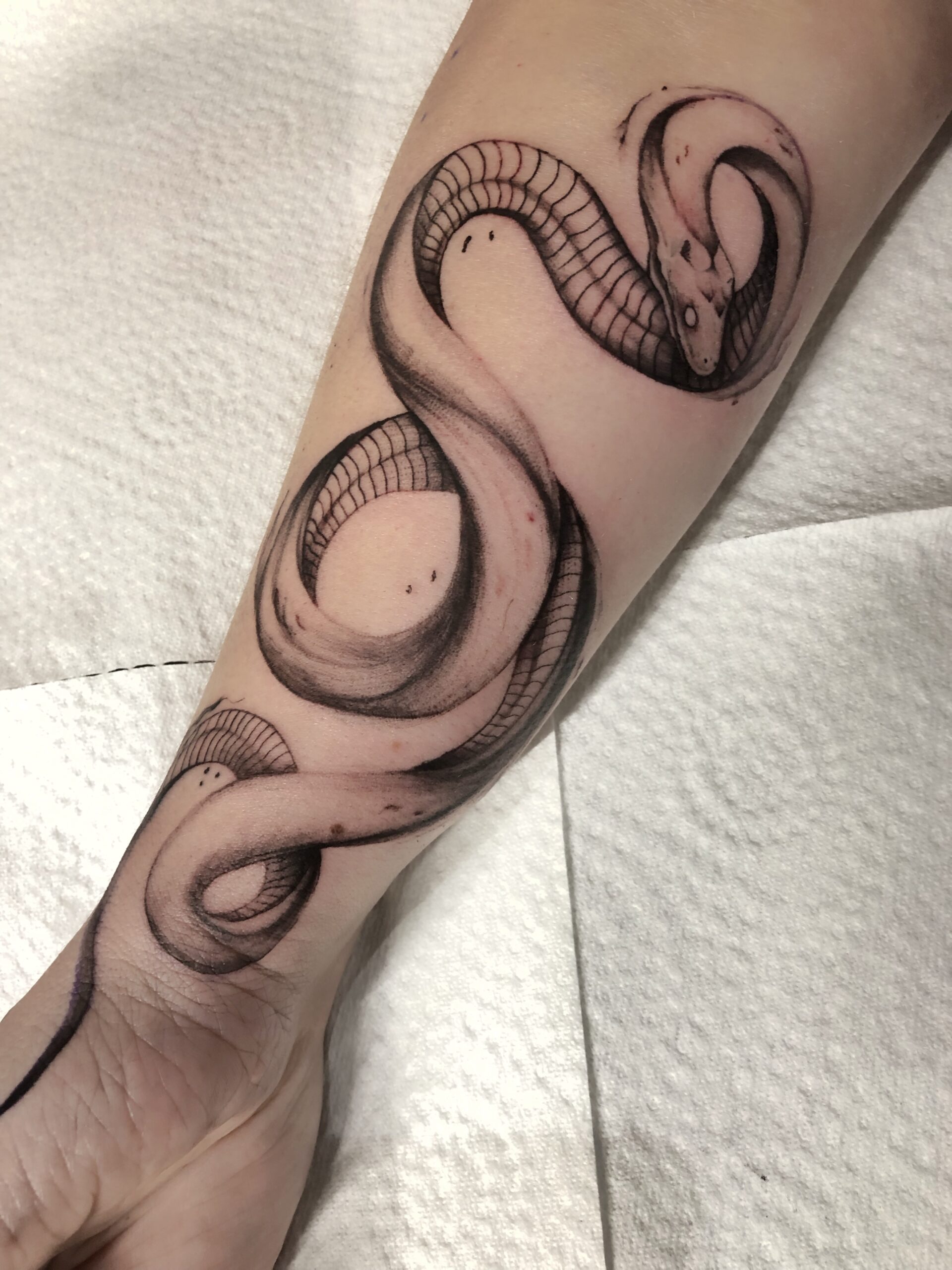 Fineline slang tattoo op been, gezet door Famke (Ocean Tattoo) bij True Spirit Tattoo Barendrecht