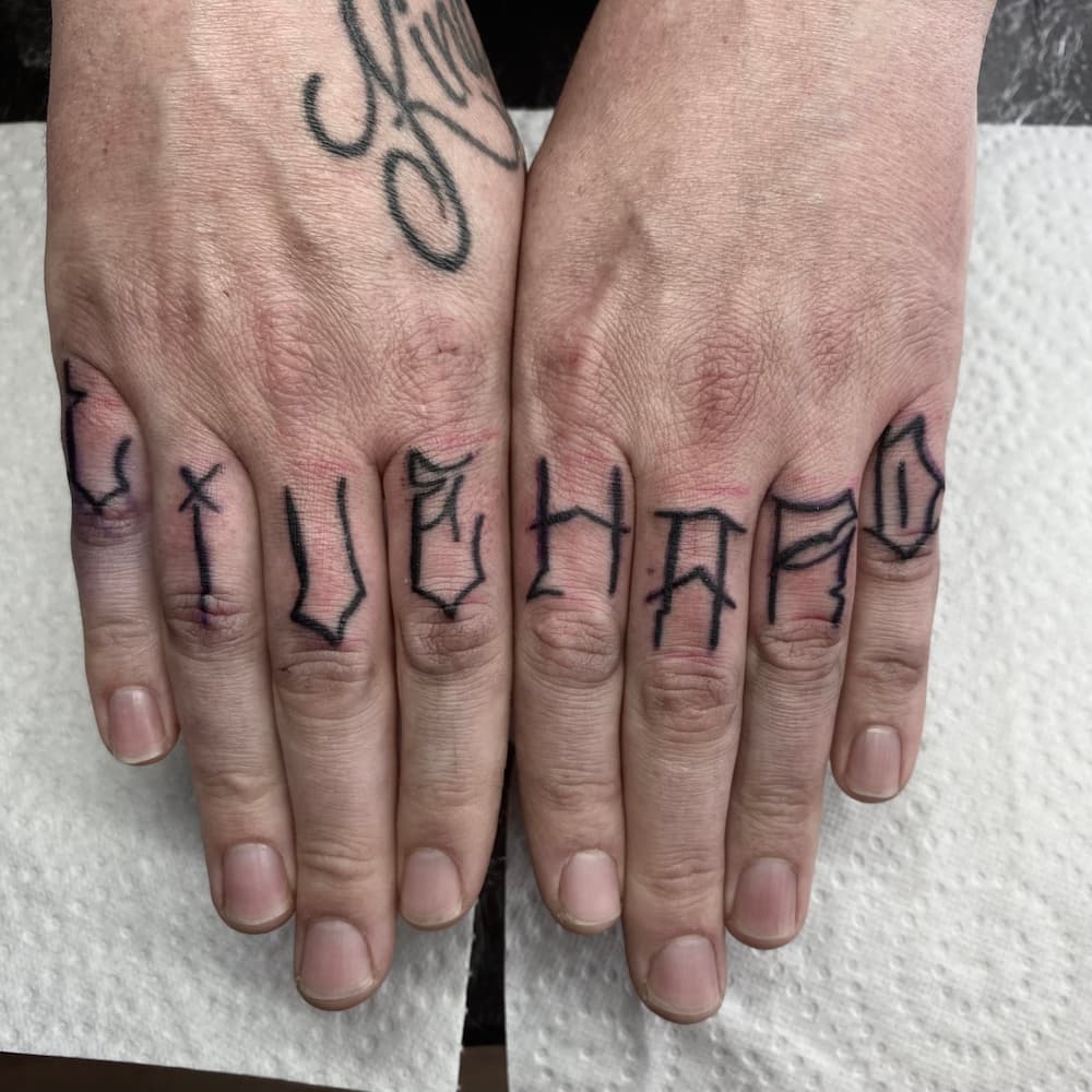 Lettering tattoo op vingers, gezet door Ernst (stayxgold) bij True Spirit Tattoo Barendrecht