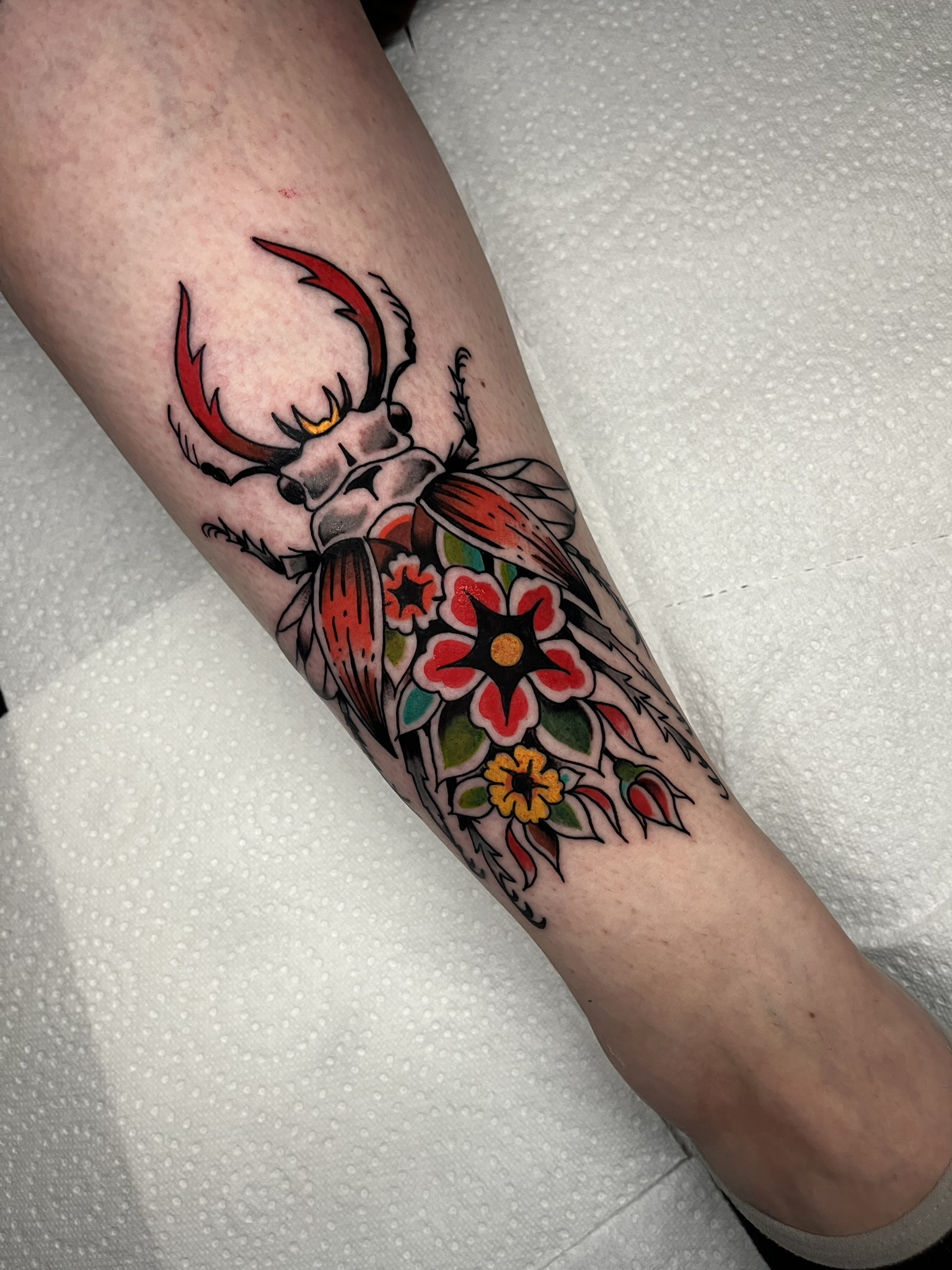 Traditional kever met bloem tattoo op been, gezet door Ernst (stayxgold) bij True Spirit Tattoo Barendrecht