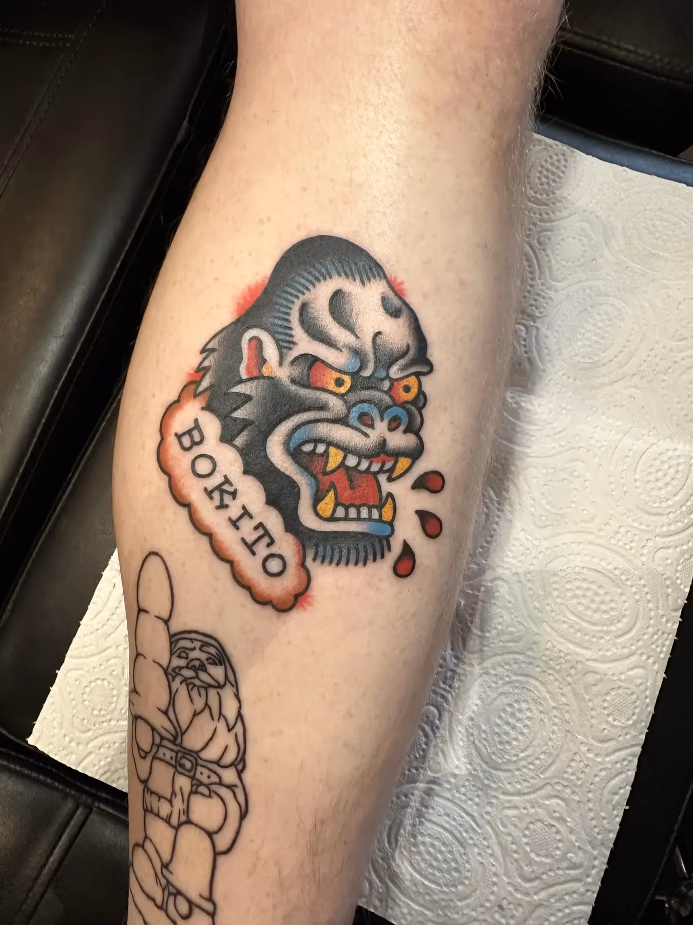 Traditional gorilla tattoo met banner op onderbeen, gezet door Nik Mart bij True Spirit Tattoo Barendrecht