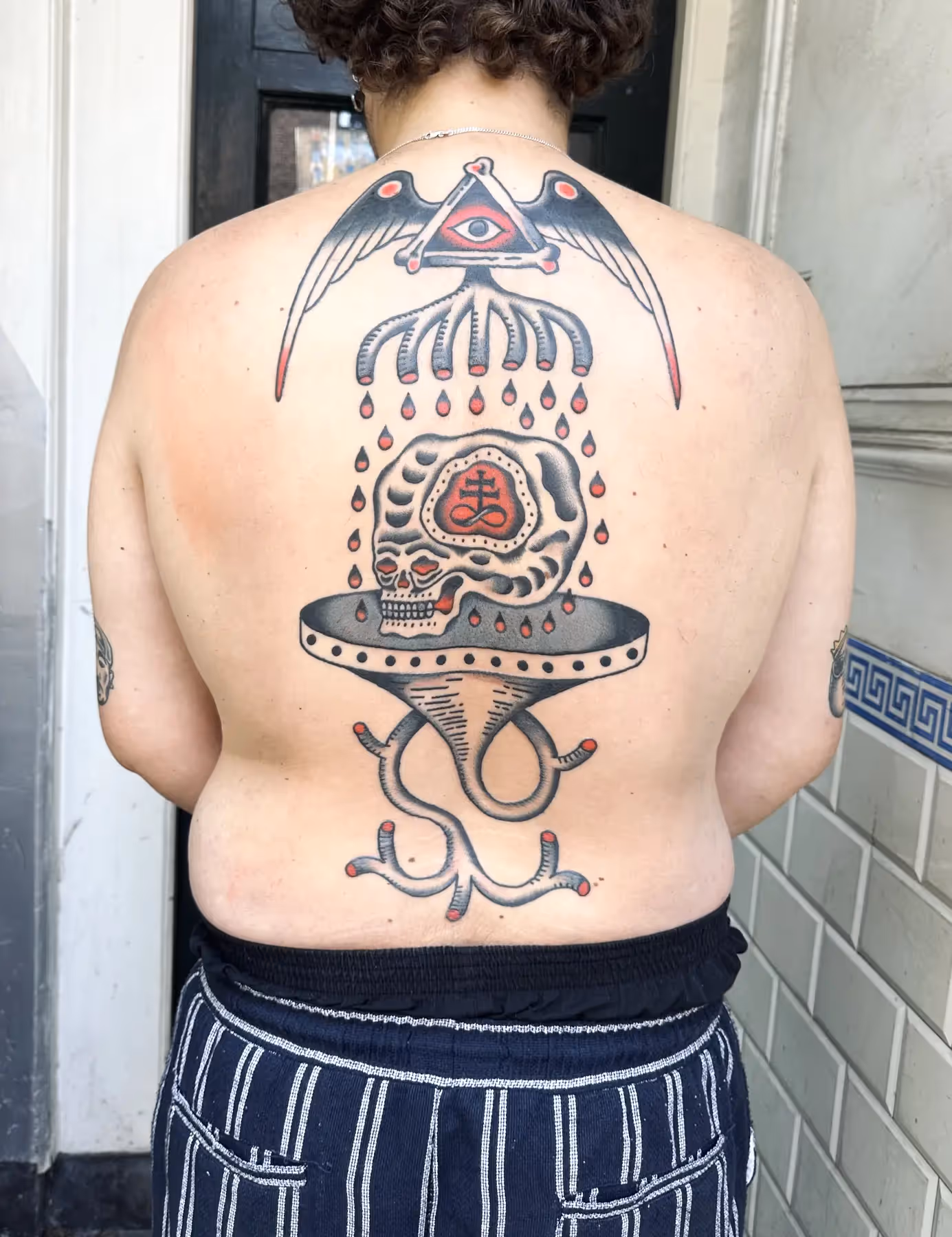Traditional rugstuk tattoo met doodshoofd en adelaar, gezet door Nik Mart bij True Spirit Tattoo Barendrecht